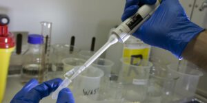 immagine di laboratorio con passaggio di liquido in provetta